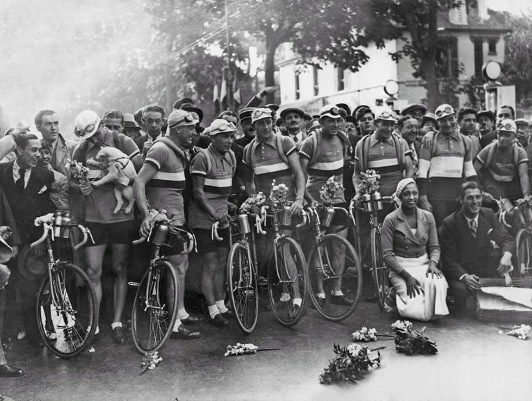 Con el fin de limitar los apaños que se realizan entre los equipos, Desgrange cambió las reglas del Tour de manera que todos los corredores de un equipo determinado tenían que pertenecer al mismo país, convirtiendo la carrera en un concurso nacional. En la carrera de 1930, ocho corredores cada uno de sus países correspondientes, participaron en los equipos de Italia, Bélgica, España y Francia, y todos los ciclistas tuvieron que utilizar el mismo tipo de bicicleta. En esta foto superior, la cantante Josephine Baker, posa con el equipo francés.