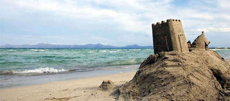 Castillo de arena en el borde de la orilla de la playa