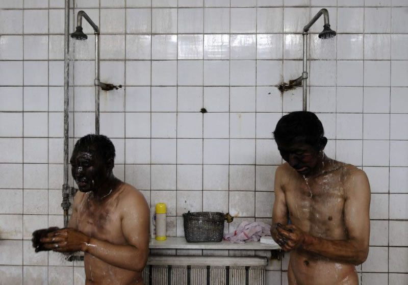 Dos hombres duchandose con ganas para quitarse la mierda