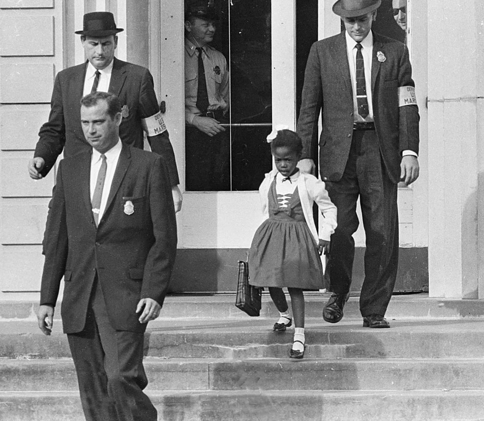 Los agentes federales de Estados Unidos escoltaron a la niña de color Ruby Bridges en su camino hacia y desde la escuela solo para personas blancas hasta su casa.