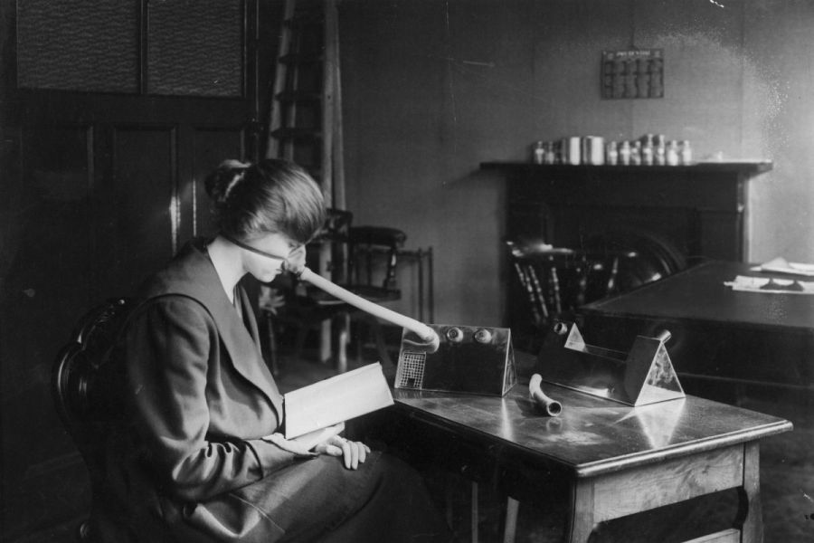 Una mujer se distancia socialmente mientras usa una máscara antigripal durante la pandemia de gripe de 1918-1919