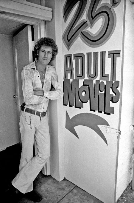 John Holmes parado en la entrada de un cine para adultos de Los Ángeles, en los años 70