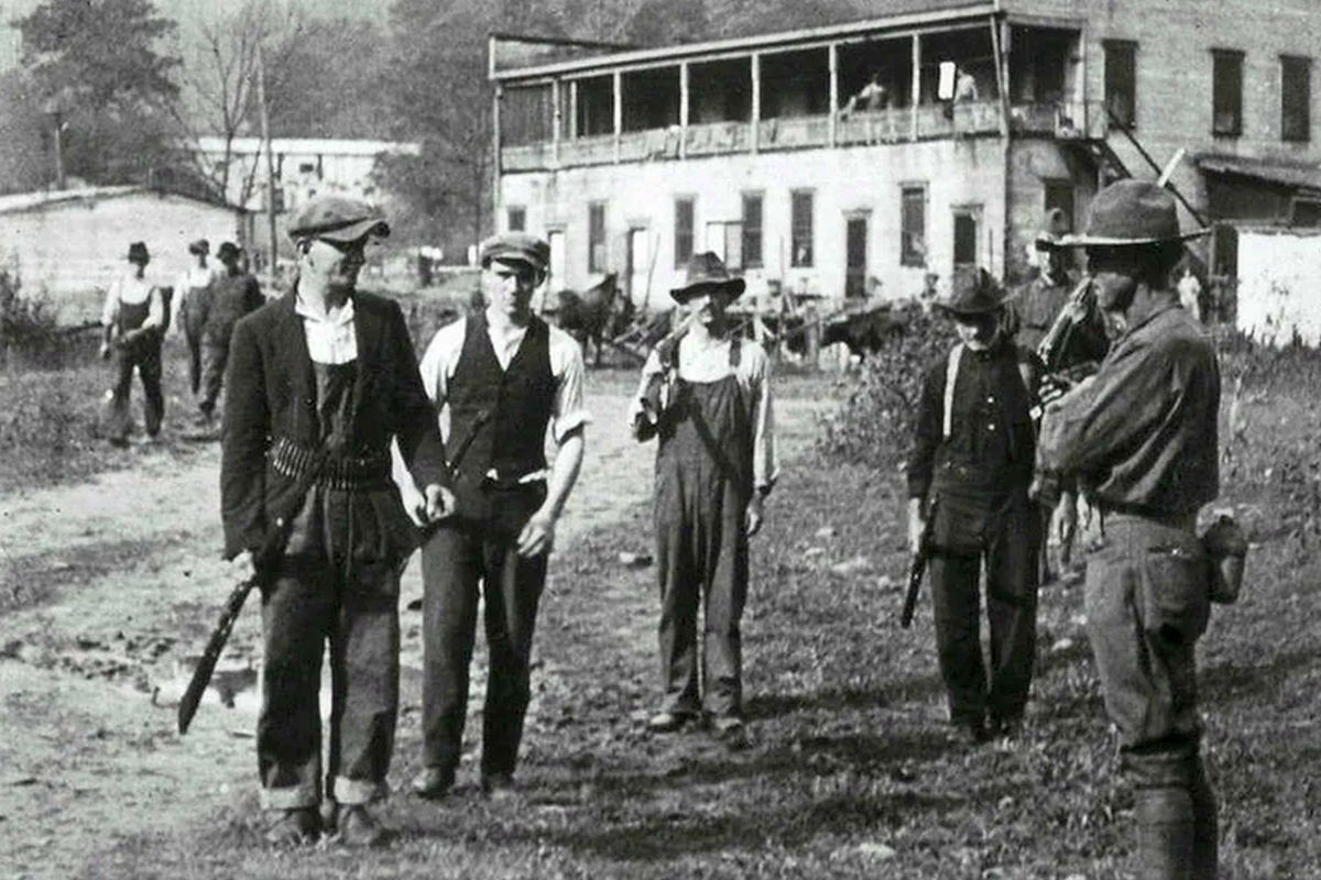 Mineros de carbón armados entregando sus armas a las tropas federales en el condado de Logan, Virginia Occidental, en septiembre de 1921, después de la conclusión de la Batalla de la Montaña Blair.