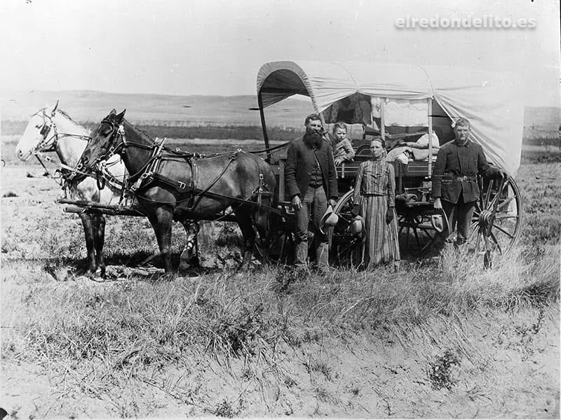 FOTOGRAFÍA DE UNA FAMILIA CON SU CARRO CUBIERTO DURANTE LA GRAN MIGRACIÓN DEL OESTE. VALLE DE LOUP, NEBRASKA → 1886