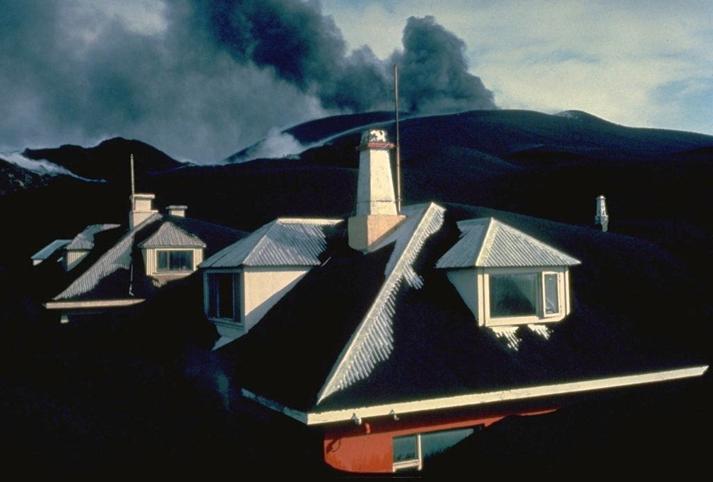El cono de cenizas de Eldfell arroja cenizas a lo lejos sobre la ciudad de Vestmannaeyjar en abril de 1973. Los gruesos depósitos de ceniza del volcán sepultaron las casas de la ciudad. La mayoría de los 5000 habitantes de la isla fueron evacuados durante la primera noche de la erupción, que comenzó el 23 de enero. Cuando la erupción terminó, el 28 de junio, el volcán había expulsado 0,02 kilómetros cúbicos de ceniza, la mayor parte de la cual cayó al mar. Tras la erupción, se trajeron 550 casas prefabricadas desde los países escandinavos y Canadá. Foto con copyright de Katia y Maurice Krafft, 1973.
